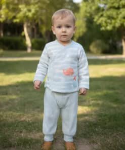 Çizgili pijamalı ayakta duran yürümeye başlayan çocuk.