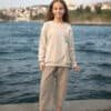 Bej sweatshirt ve pantolon giyen kız.