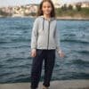 Gri kapşonlu ve mavi pantolonlu kız.