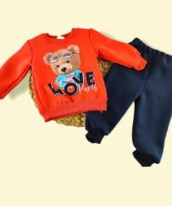 Çocuk turuncu sweatshirt ve koyu mavi eşofman altı takımı.