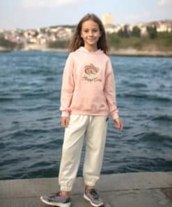 Pembe kapşonlu ve beyaz pantolonlu kız.