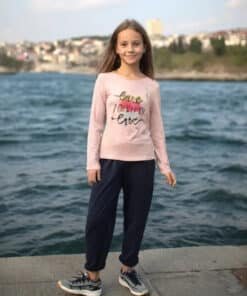 Pembe uzun kollu gömlek ve koyu renk pantolon giyen kız.