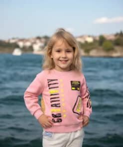 Pembe sweatshirt’lü gülümseyen çocuk.