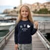 Lacivert sweatshirt ve tüvit etek giyen kız.