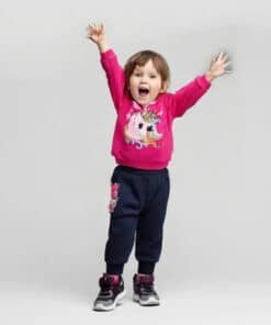 Pembe tek boynuzlu atlı sweatshirt ve koyu mavi eşofman altı giyen heyecanlı yürümeye başlayan çocuk.
