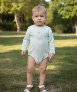 Bodysuit giymiş ayakta duran yürümeye başlayan çocuk.