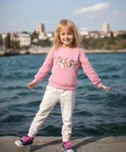 Pembe sweatshirt ve beyaz pantolonlu kız.