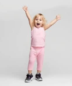 Pembe kıyafetli heyecanlı yürümeye başlayan çocuk.
